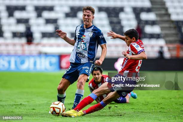 Juan Sanabria of Atletico San Luis struggles for the ball against Paulino de la Fuente of Pachuca during the 16th round match between Pachuca and...