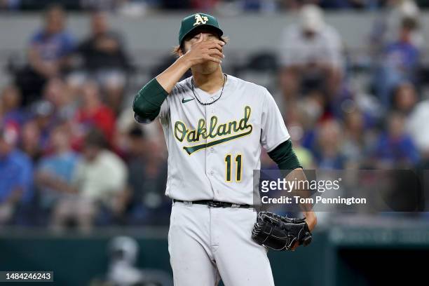 Shintaro Fujinami of the Oakland Athletics reacts after giving up a two-run double against Jonah Heim of the Texas Rangers in the bottom of the...