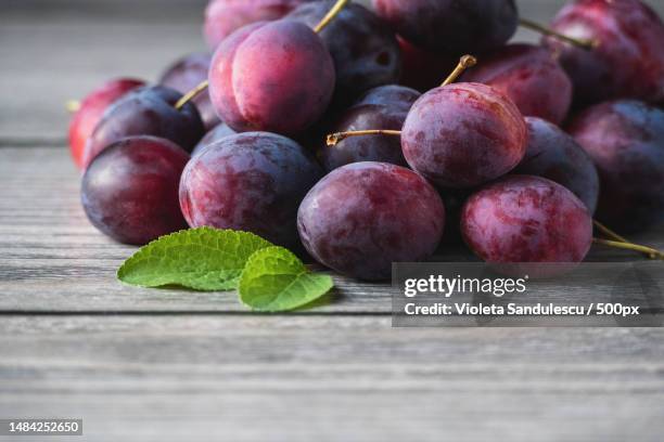 harvested plums on wooden table,purple prune fruits,green leaf,copy space - red plum stock pictures, royalty-free photos & images