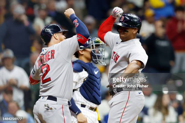 Rafael Devers of the Boston Red Sox is congratulated by Justin Turner after hitting a two-run home run in the sixth inning against the Milwaukee...