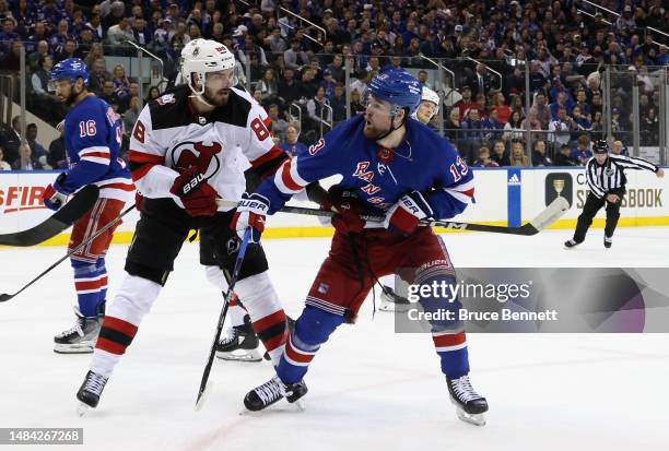 Kevin Bahl of the New Jersey Devils checks Alexis Lafreniere of the New York Rangers during the second period during Game Three in the First Round of...