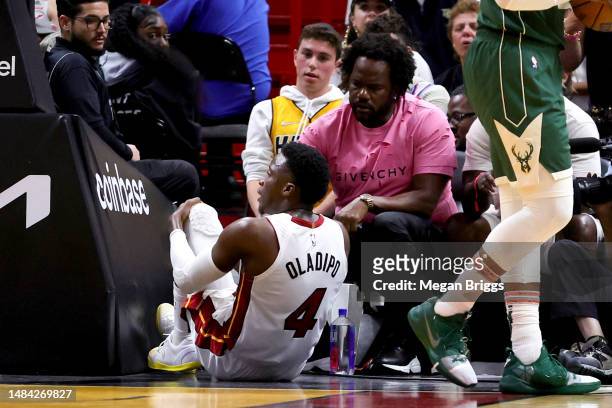 Victor Oladipo of the Miami Heat reacts after suffering an injury during the fourth quarter against the Milwaukee Bucks during Game Three of the...