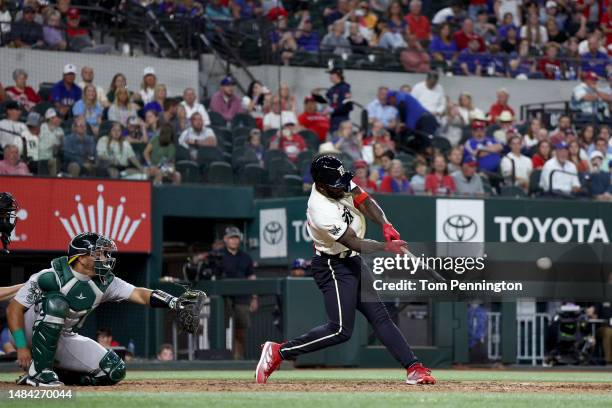 Adolis Garcia of the Texas Rangers hits a two-run double against James Kaprielian of the Oakland Athletics in the bottom of the seventh inning at...