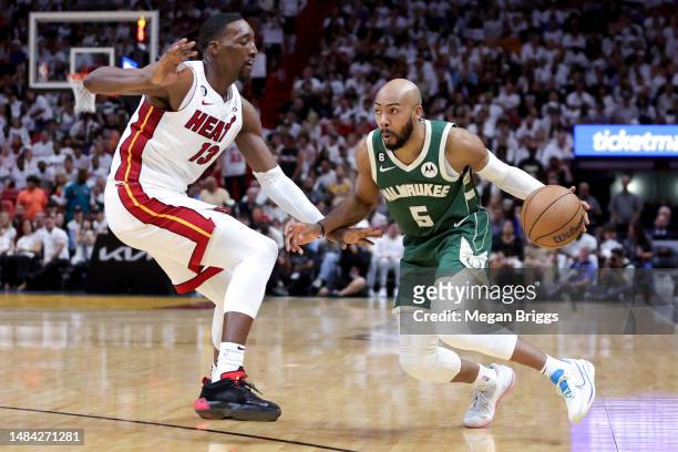 Jevon Carter of the Milwaukee Bucks dribbles the ball against Bam Adebayo of the Miami Heat during the fourth quarter of Game Three of the Eastern...