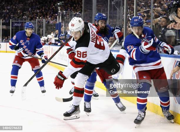 Adam Fox of the New York Rangers trips up Jack Hughes of the New Jersey Devils during the third period in Game Three in the First Round of the 2023...