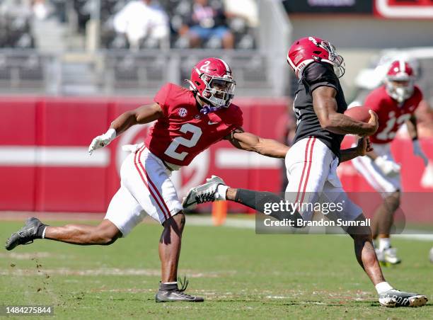 Caleb Downs of the Crimson Team hauls down Jalen Milroe of the White Team during the first half of the Alabama Spring Football Game at Bryant-Denny...