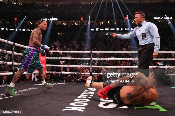 Gervonta Davis in the green and purple trunks knocks Ryan Garcia in the black trunks down in the second round during their catchweight bout at...