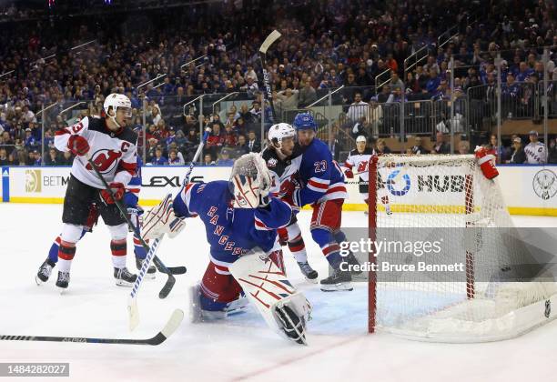 Nico Hischier and Dawson Mercer of the New Jersey Devils watch as a shot by Dougie Hamilton goes in the net against Igor Shesterkin and the New York...