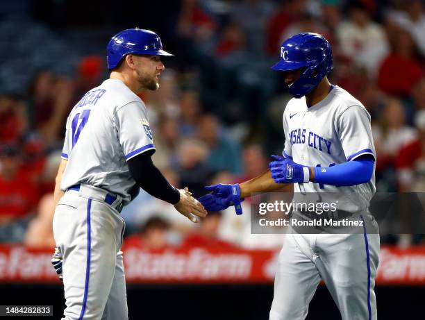 Hunter Dozier and Edward Olivares of the Kansas City Royals celebrate a run against the Los Angeles Angels in the ninth inning at Angel Stadium of...