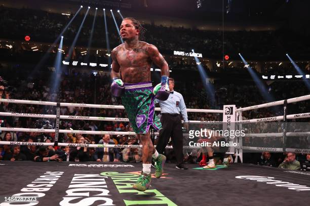 Gervonta Davis in the green and purple trunks reacts after defeating Ryan Garcia in the black trunks by knockout in the seventh round during their...