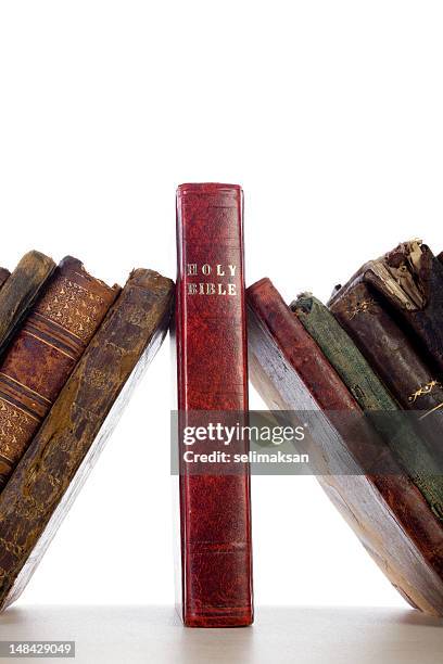 antique books leaning on holy bible as keystone - biblical event stock pictures, royalty-free photos & images