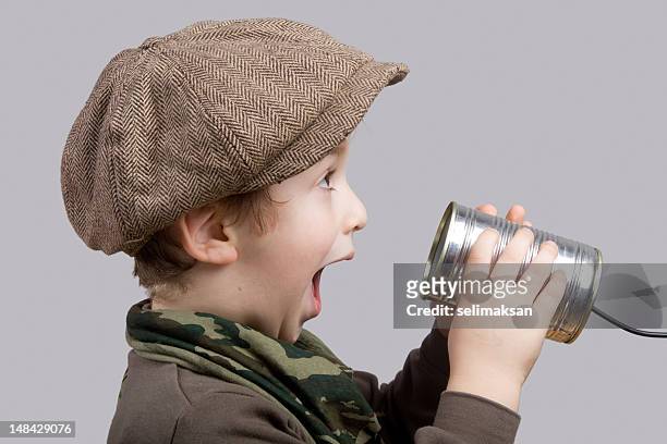 cute little boy surprised while communicating on tin can phone - listening tin can stock pictures, royalty-free photos & images