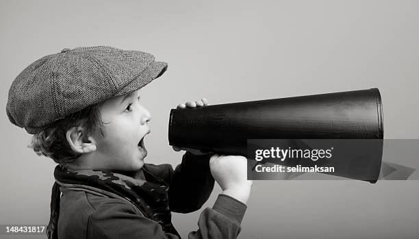 little boy wearing newsboy cap shouting with megaphone - newspaper boy stock pictures, royalty-free photos & images