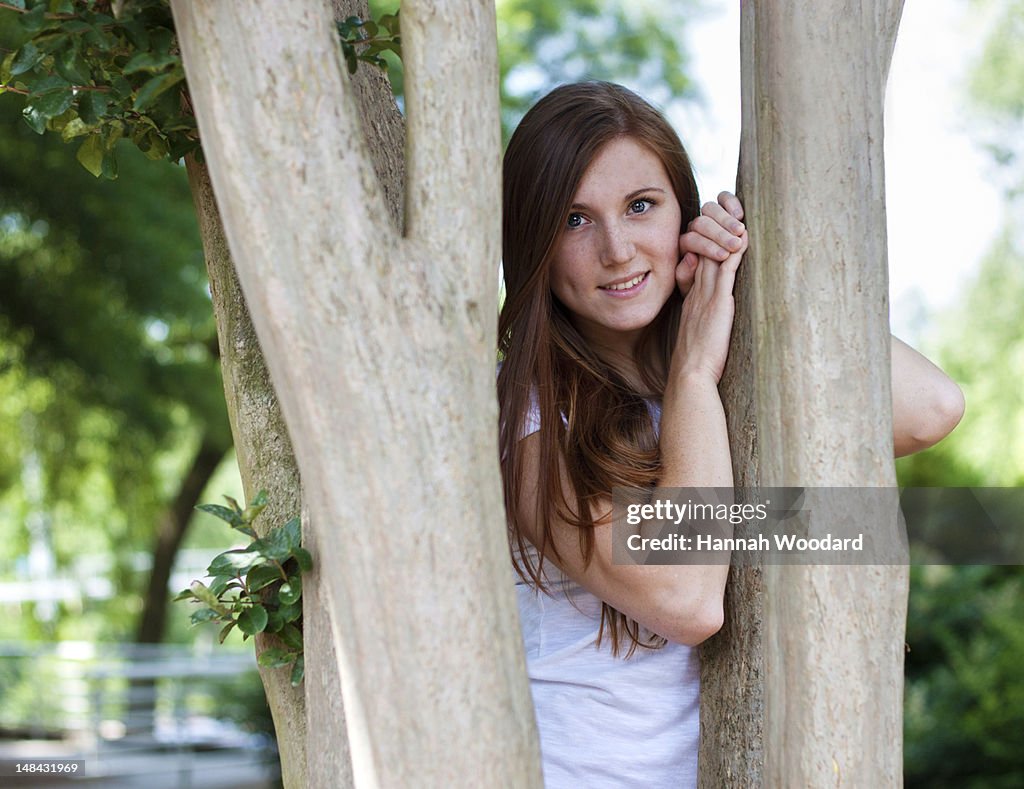 Woman leaning against tree