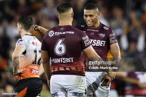 John Bateman of the Wests Tigers looks dejected as Josh Schuster and Samuela Fainu of the Sea Eagles celebrate victory during the round eight NRL...