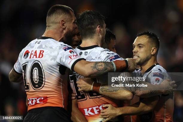 David Klemmer, John Bateman and Luke Brooks of the Wests Tigers celebrate with Staford To'a of the Wests Tigers aftre he scored a try during the...