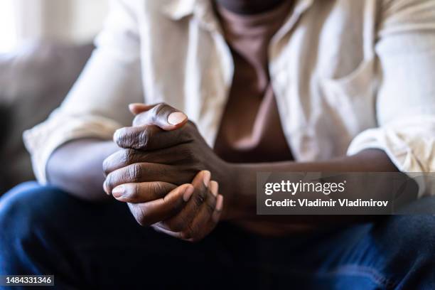 close up of a pair of hands clasped together - man waiting couch stock pictures, royalty-free photos & images