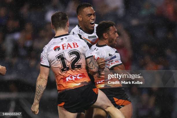 Joe Ofahengaue, John Bateman and Apisai Koroisau of the Wests Tigers celebrate Apisai Koroisau of the Wests Tigers scoring a try during the round...