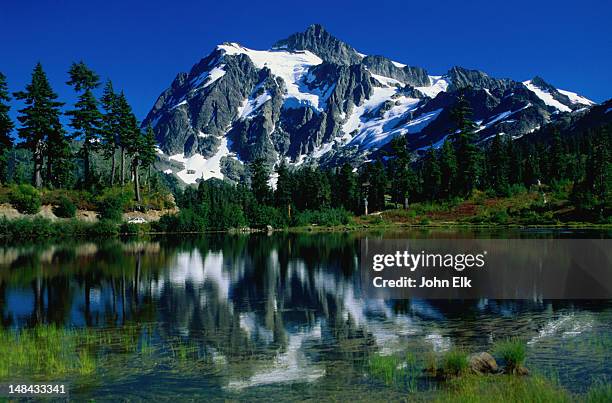 mt shuksan, capped with snow, reflected in the waters of picture lake - mt baker scenic byway, washington - mt shuksan stock-fotos und bilder