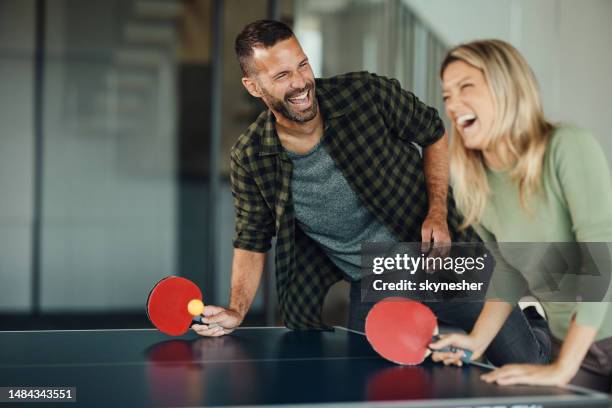 cheerful couple having fun while playing table tennis. - table tennis stock pictures, royalty-free photos & images