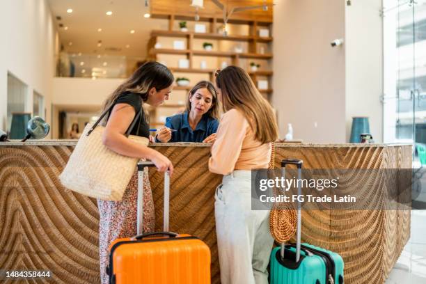 receptionist talking customers at hotel lobby - área de check in imagens e fotografias de stock