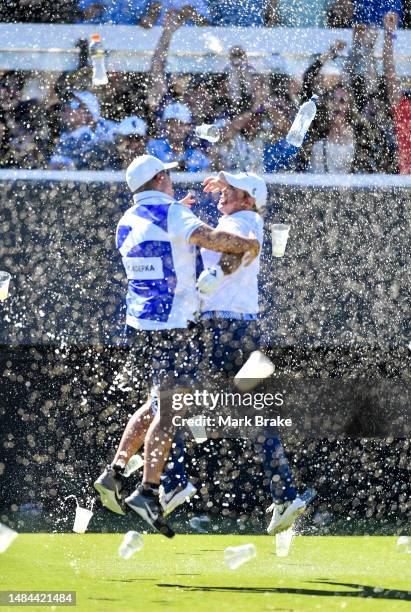 Chase Koepka of the Smash celebrates a hole in one with his caddie on the 12th showered in beer from the crowd during day three of Liv Golf Adelaide...