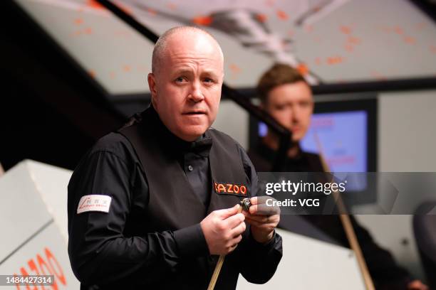 John Higgins of Scotland chalks the cue in the second round match against Kyren Wilson of England on day 9 of the 2023 Cazoo World Championship at...