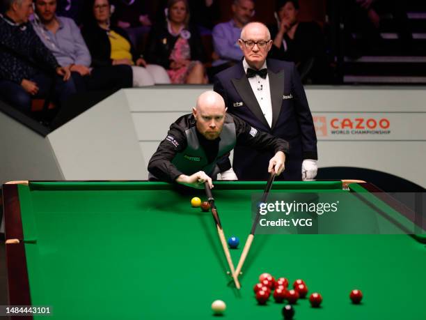 Gary Wilson of England plays a shot in the second round match against Mark Selby of England on day 8 of the 2023 Cazoo World Championship at Crucible...