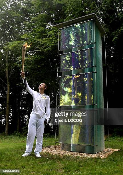 In this handout image provided by LOCOG, Torchbearer 044 Ryan Hodd Jarvis holds the Olympic Flame at Cass Sculpture Park, Goodwood Estate, Hampshire...