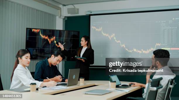 young asian businesswoman talking about company's declining performance to teammates in meeting room. - shareholder's meeting stock pictures, royalty-free photos & images