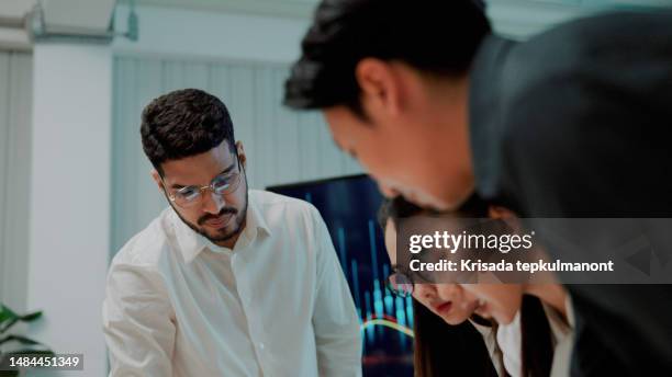four office workers discussing data while creating new project in meeting room. - shareholders meeting stock pictures, royalty-free photos & images