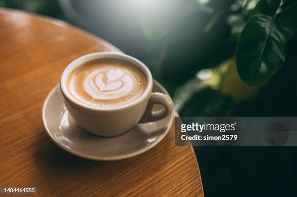 sip, savor, and enjoy: a perfectly crafted cappuccino with a beautiful twist - coffee art stockfoto's en -beelden