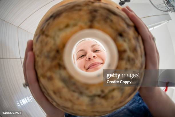 young woman putting kugelhupf cake on serving plate from silicone mold - pound cake stock pictures, royalty-free photos & images