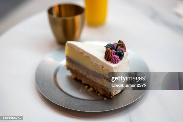 freshly made blueberry cheesecake slice cake on table. - layer cake stock pictures, royalty-free photos & images