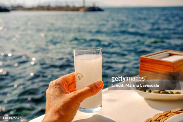 drinking turkish raki with a sea view. personal perspective. - ouzo stock pictures, royalty-free photos & images
