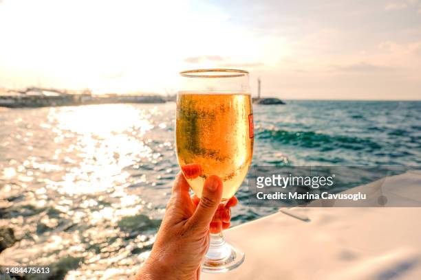 drinking beer with a sea view. personal perspective. - beer glass stock-fotos und bilder