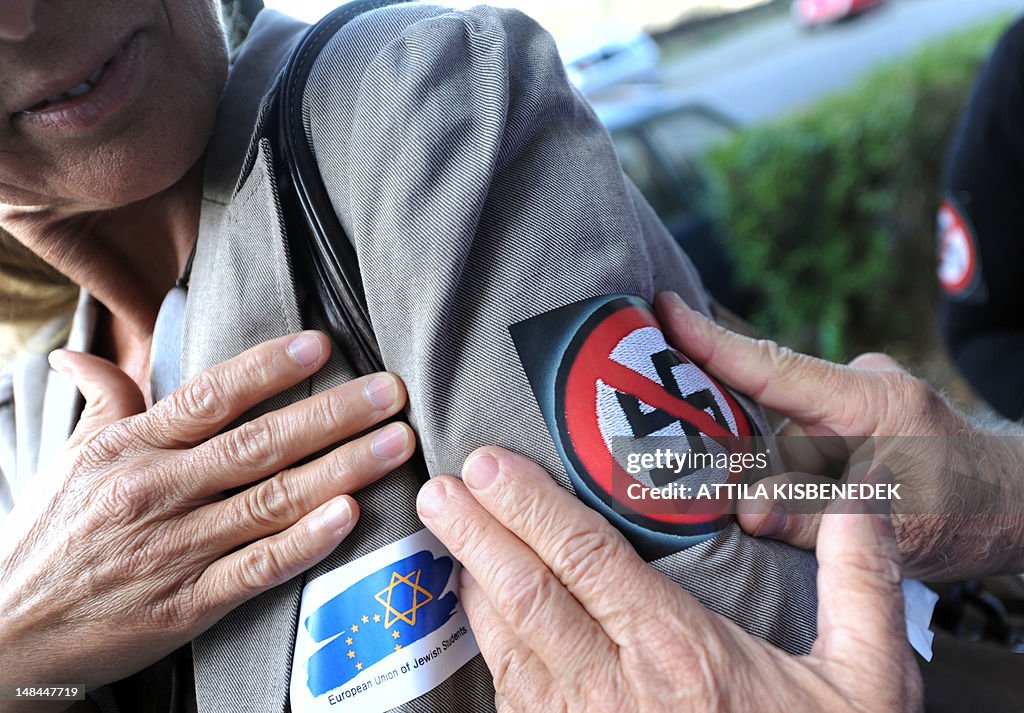A person sticks a 'No Nazi' symbol in fr