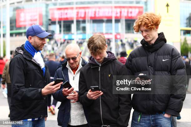 Brighton & Hove Albion fans check their phone's as they receive an emergency alert test text from the UK Government during the Premier League match...