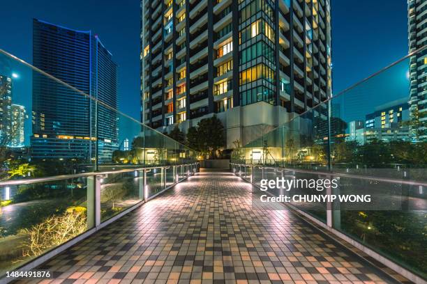 apartment buildings in a public area in tokyo at night - kachidoki tokyo stock pictures, royalty-free photos & images