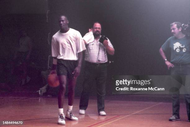 Chicago Bulls basketball player Michael Jordan is about to shoot a Wilson basketball surrounded by still photographers while filming a Nike Air...