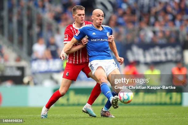 Michael Frey of FC Schalke 04 passes the ball whilst under pressure from Matthias Ginter of Sport-Club Freiburg during the Bundesliga match between...