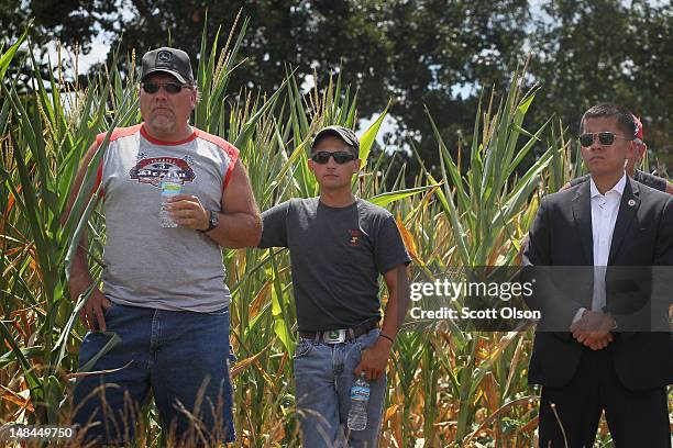 Farmers Dave Witger and Dylan Louks listen as Illinois Gov. Pat Quinn holds press conference in front of drought-damaged corn field on the farm of...