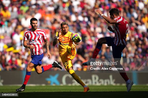 Raphinha of FC Barcelona battles for possession with Mario Hermoso of Atletico Madrid during the LaLiga Santander match between FC Barcelona and...