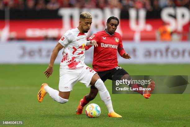 Benjamin Henrichs of RB Leipzig battles for possession with Jeremie Frimpong of Bayer 04 Leverkusen during the Bundesliga match between Bayer 04...