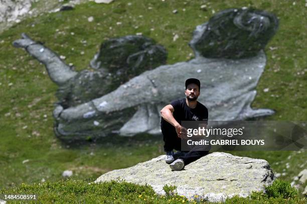 French Land artist Guillaume Legros aka "Saype" poses next to his new giant land art fresco entitled: "La Grande Dame" in Courmayeur, next to the...