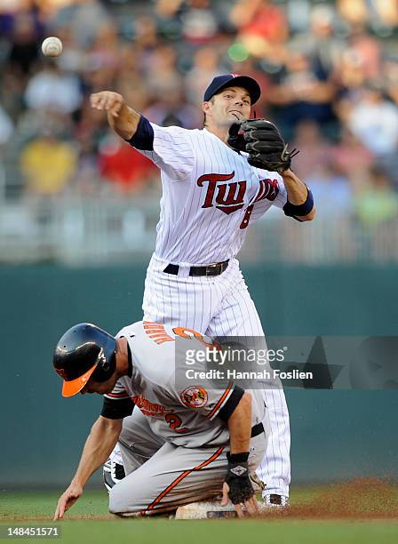 Hardy of the Baltimore Orioles is out at second base as Jamey Carroll of the Minnesota Twins turns a double play during the first inning on July 16,...