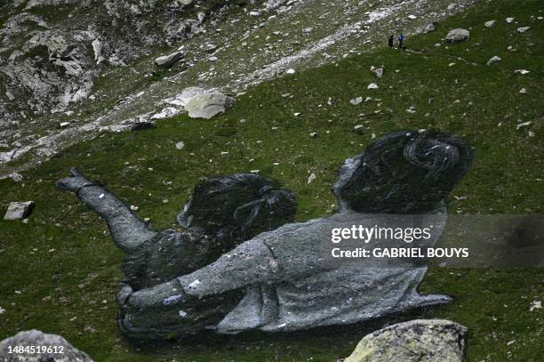 Pedestrians walk by French Land artist Guillaume Legros aka "Saype" new giant land art fresco entitled: "La Grande Dame" in Courmayeur, on July 3,...