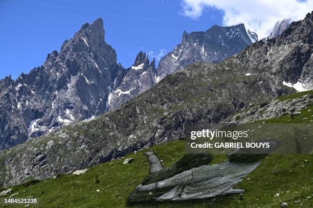 French Land artist Guillaume Legros aka "Saype" works on his new giant land art fresco entitled: "La Grande Dame" in Courmayeur, next to the Mont...