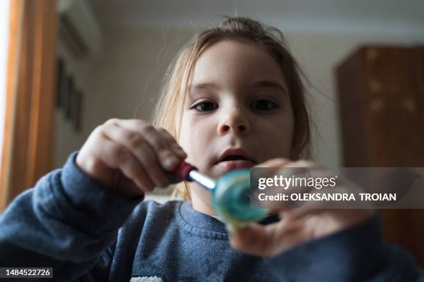 child girl painting with paint and brush, front view at home. creative education - draw attention stock pictures, royalty-free photos & images