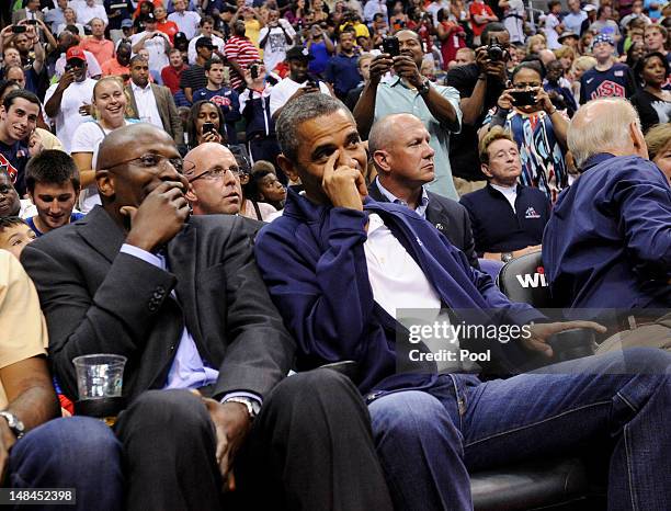 President Barack Obama shares a laugh with former White House aide Reggie Love as they watch the US Senior Men's National Team and Brazil play during...